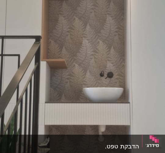 כיור עם טפט עלים דקורטיבי על הקיר